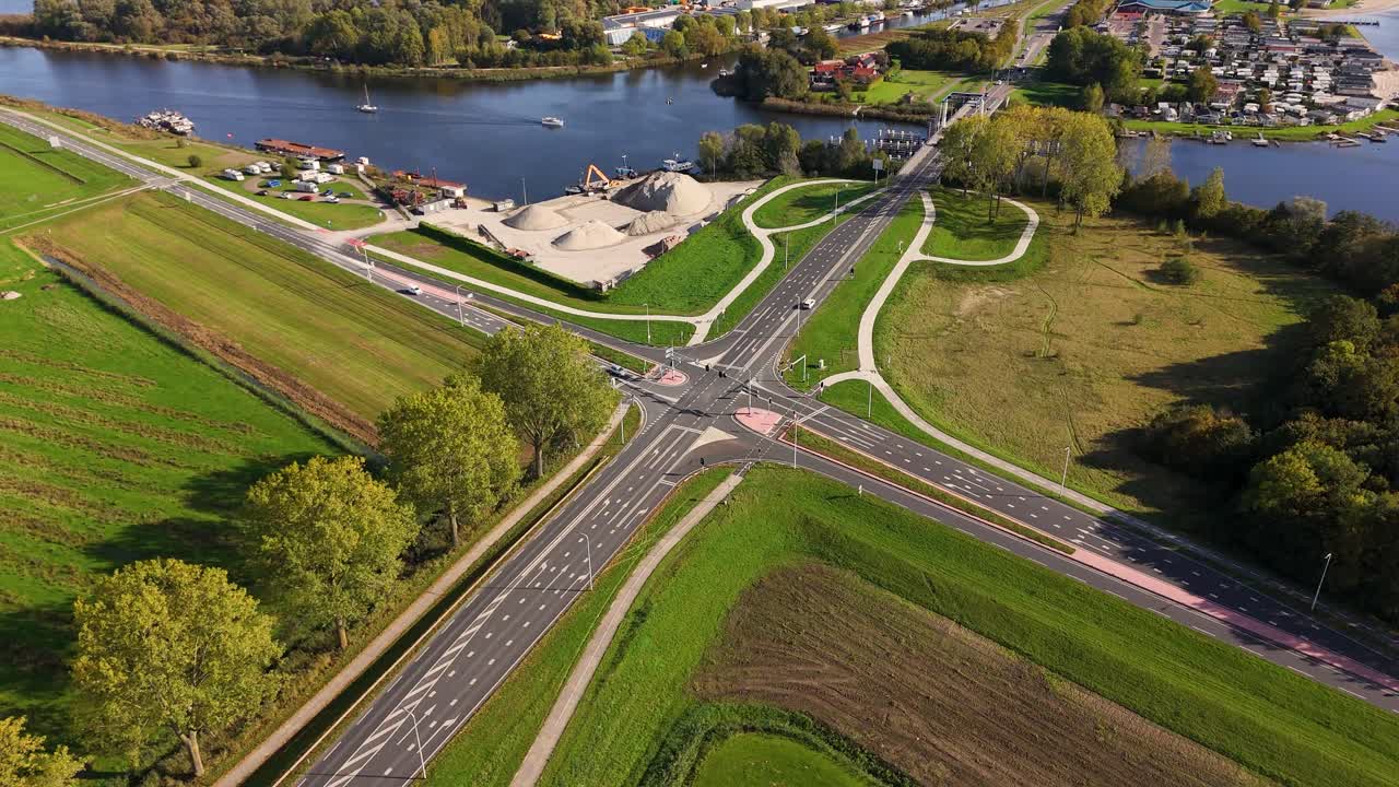 Aerial view of an intersection with roads, river, and trees