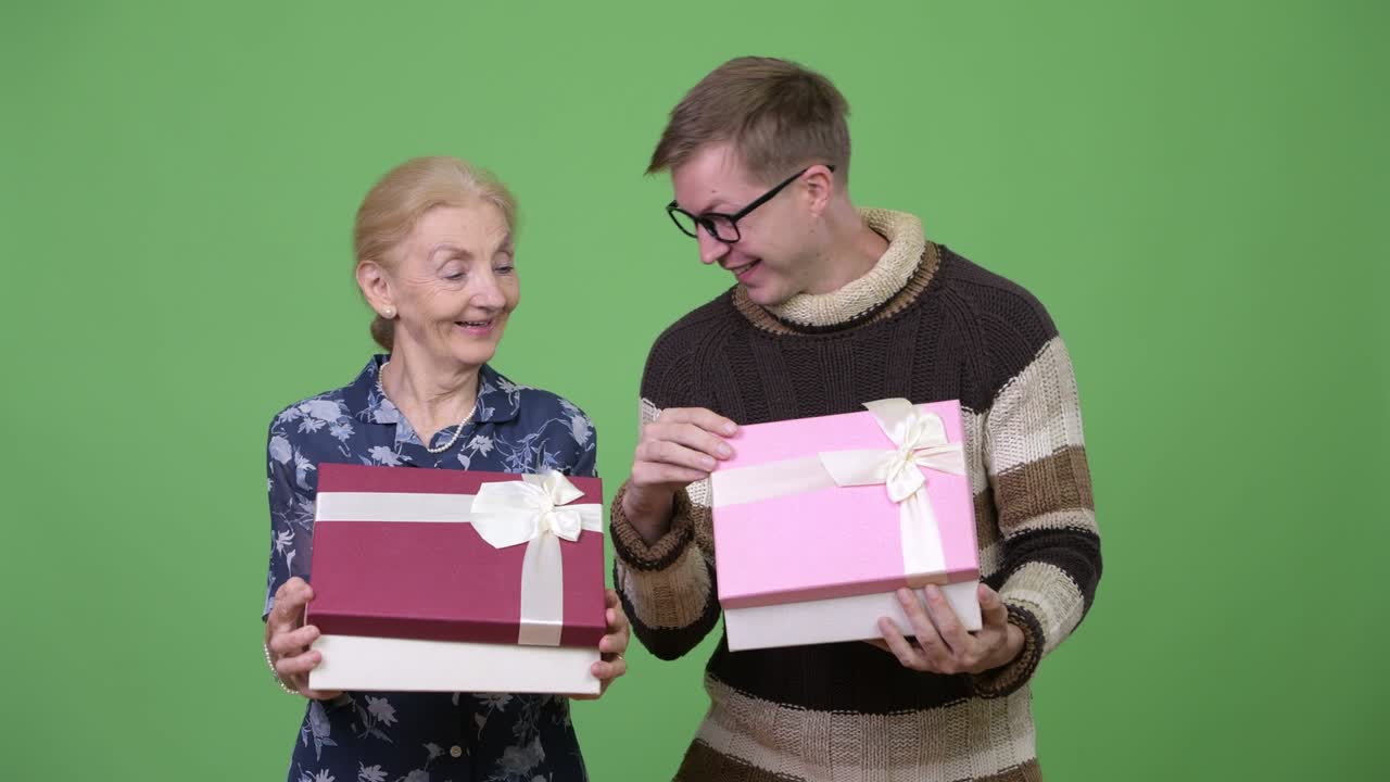 Happy grandmother and grandson opening gift box together