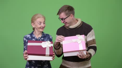 happy grandmother and grandson opening gift box together