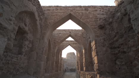 dollying in and tilting down through teh ancient arches of the bahrain fort