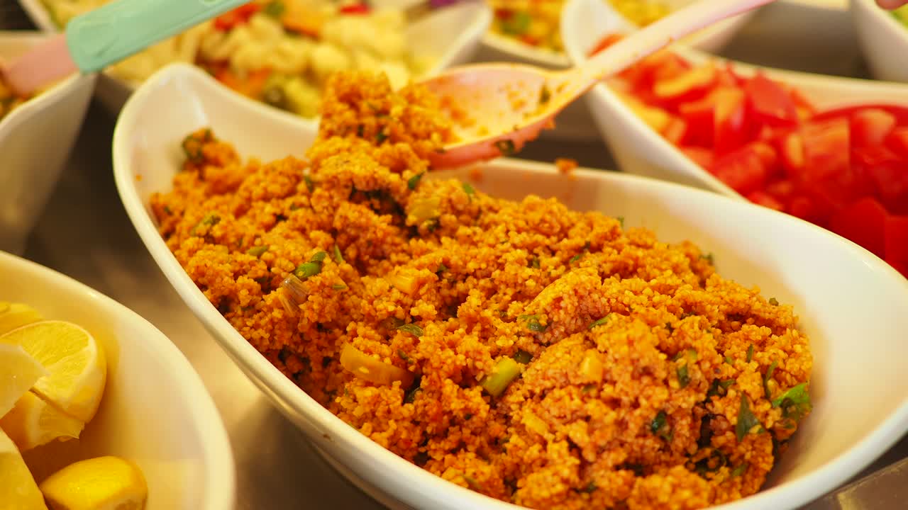 Prelevare l'insalata di bulgur tradizionale da una ciotola da portata