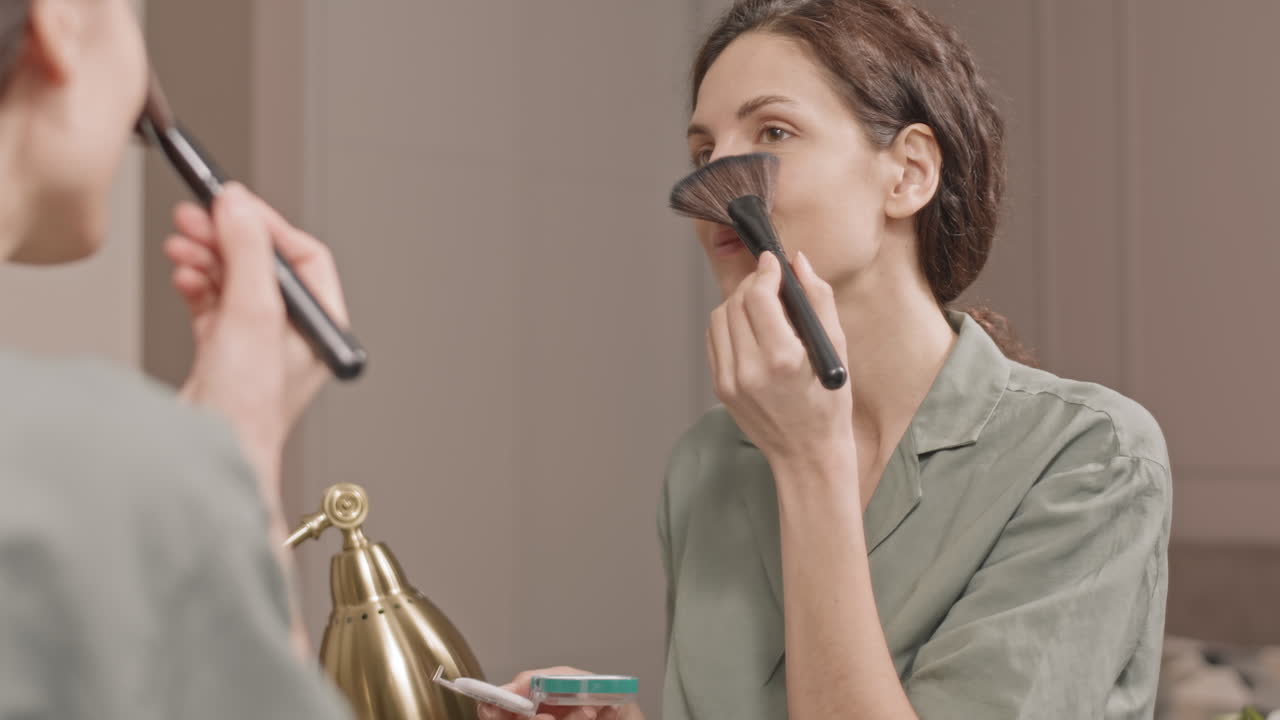 Woman Applying Makeup in Mirror