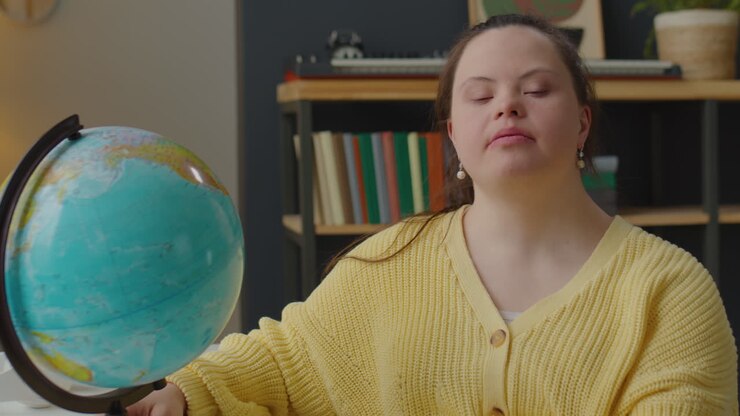 Ritratto di ragazza allegra con sindrome di Down e un mappamondo