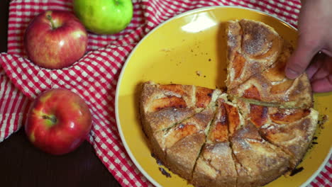 fresh apple pie cutted into pieces. hand take all slices of apple pie from plate