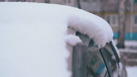 thick white snowdrift lies on car roof on spring day