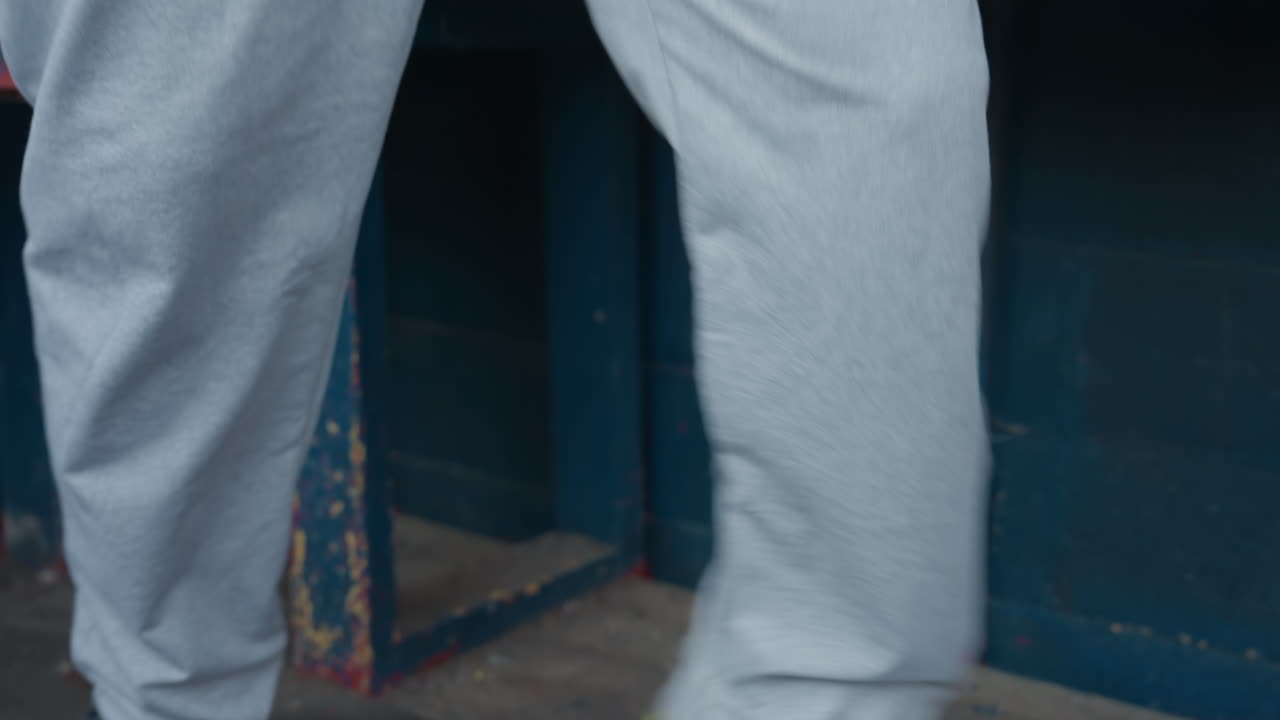 Atleta preparándose con estiramientos suaves, persona haciendo movimientos ligeros con ropa deportiva, atleta con ropa informal haciendo ejercicios de calentamiento antes de empezar la competición