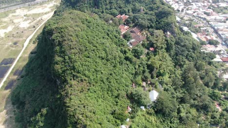 Drone-aerial-view-in-Vietnam-flying-over-Da-Nang-coast-city-marble-mountains-top-view-full-of-trees-on-a-sunny-day