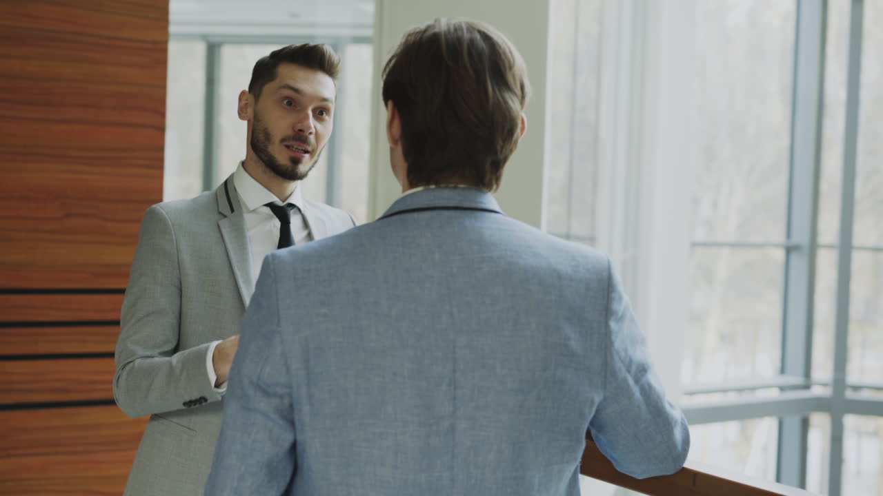 Businessmen Discussing in an Office Corridor