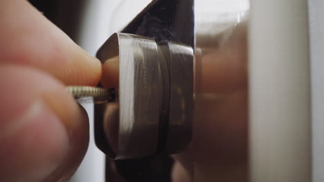 man puts small coin into split of lock to open slammed door