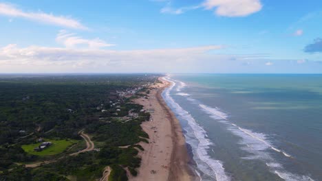 Drone-shot-flying-along-the-beach-in-Cariló,-Argentina