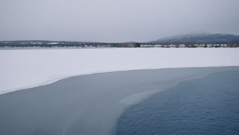 snowscape offshore with distant structures in mountain background after heavy snowfall