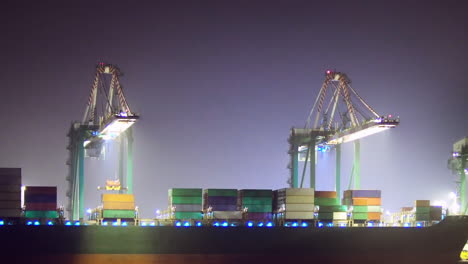 loading a container ship at night, zoom out ease