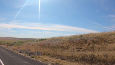 pov por la ventana del pasajero mientras conduce a través de una zona agrícola de las tierras altas de okanogan en el centro norte del estado de washington