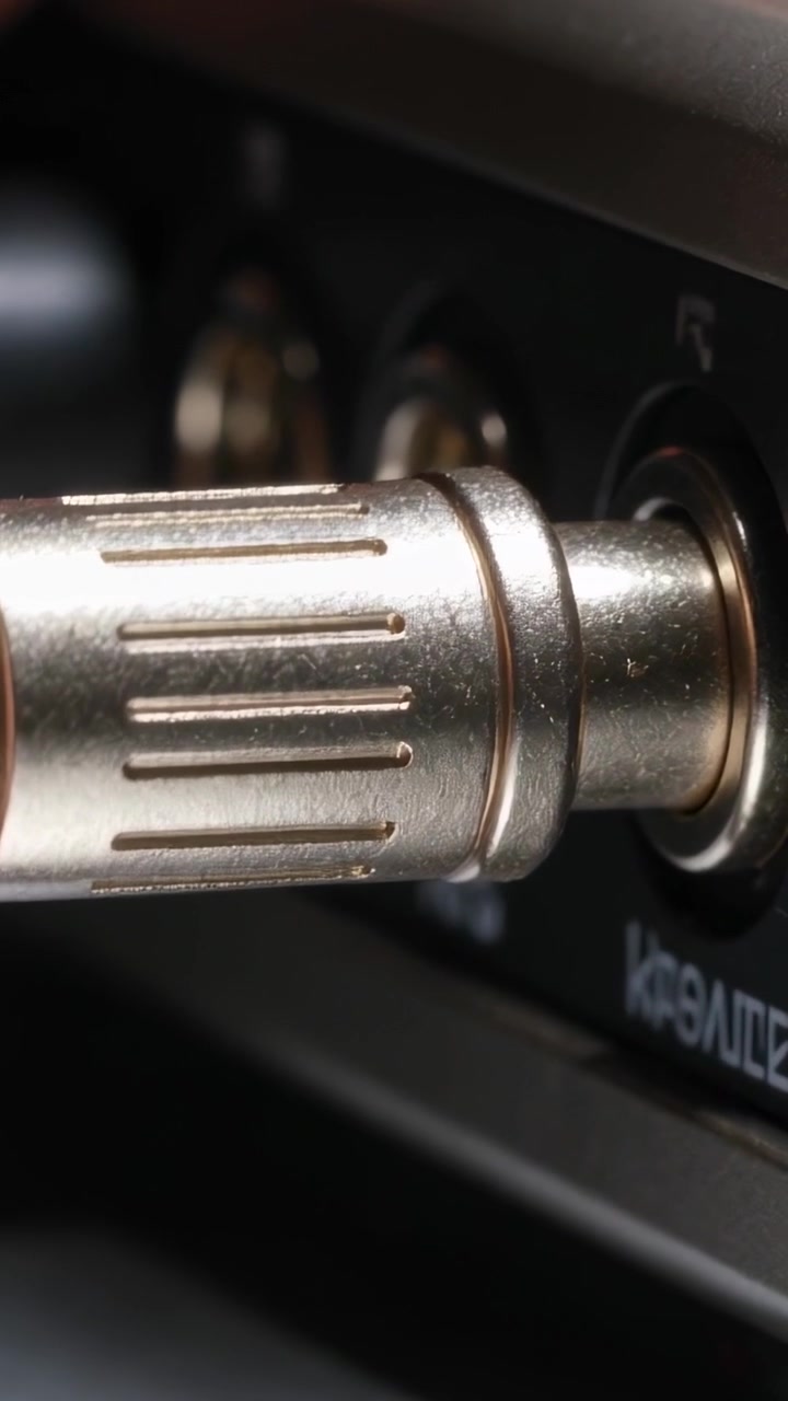 Vertical video: Pushing metal plug into right jack on audio panel, fingertip guiding final seating