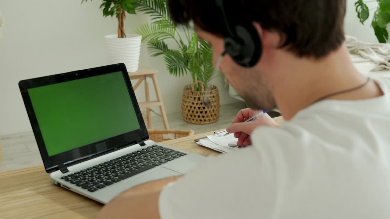 Close-up freelancer male hands using green screen chroma key laptop typing working in light office with modern computer