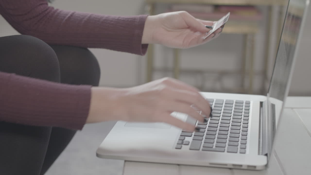 крупный план молодой женщины, вводящей данные своей карты в ноутбук для совершения онлайн-покупки, кулаки накачиваются, чтобы отпраздновать - без оценки