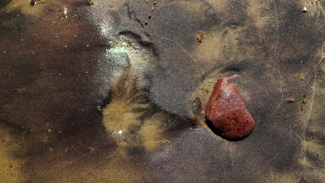 The-lonely-stone-lies-on-the-shore,-the-water-splashes-on-the-stone