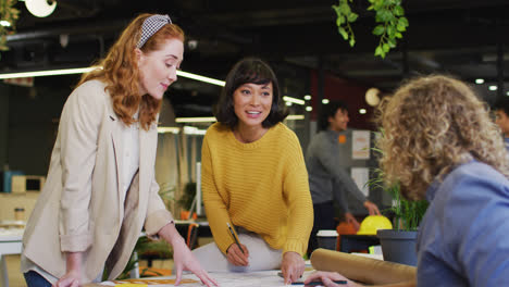 Gente-De-Negocios-Feliz-Y-Diversa-Discutiendo-El-Trabajo-Con-Esquema-En-La-Oficina