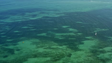 Hochschwenkbare-Weitwinkelaufnahme-Der-Tropischen-Hauptstadt-Joao-Pessoa,-Paraiba,-Brasilien-Von-Der-Berühmten-Roten-Sandinsel-Mit-Türkisfarbenem-Meerwasser-Und-Einer-Großen-Wolkenkratzerstadtlandschaft-An-Einem-Sommertag