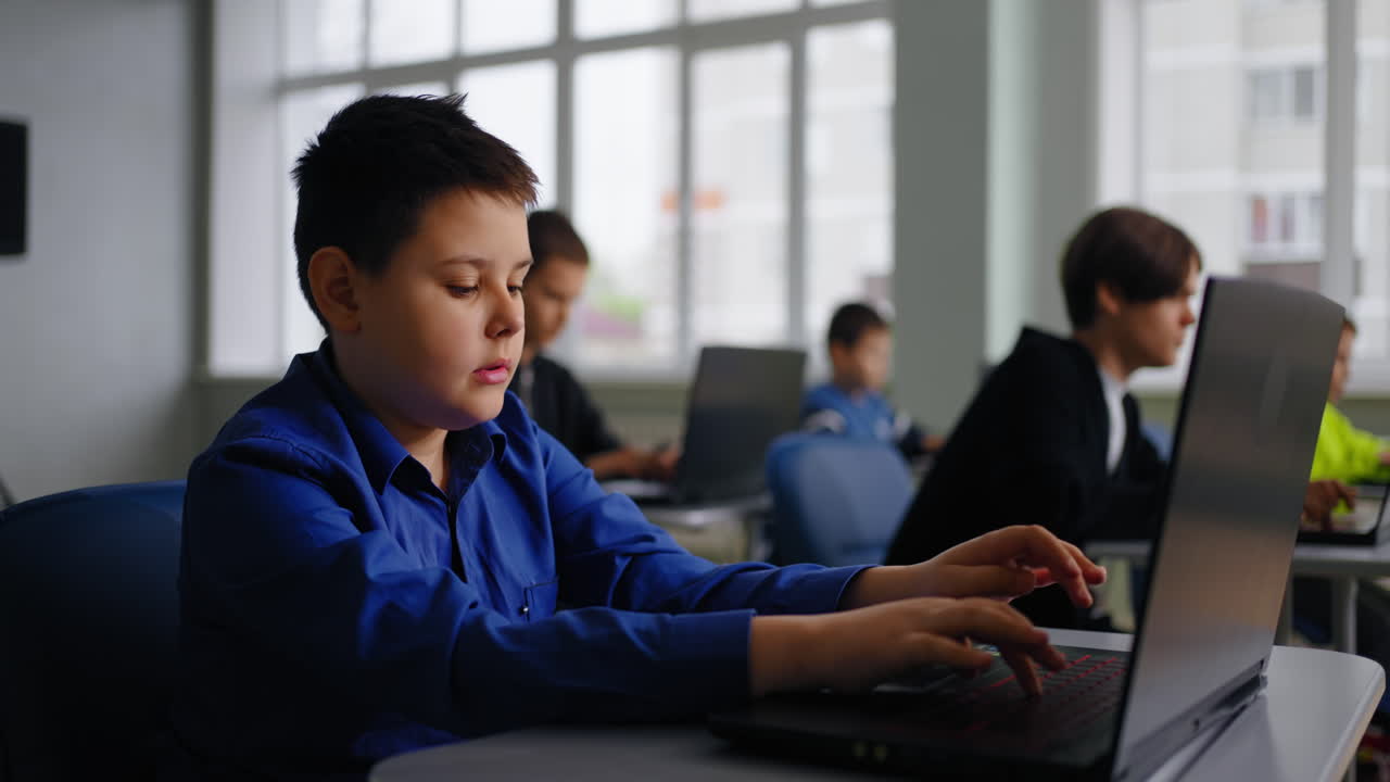 학교 교실 에서 노트북 을 사용하는 소년