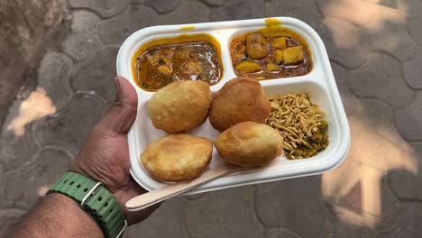 shot of changani style club kachori served with puri, alu ki sabji and bhujia