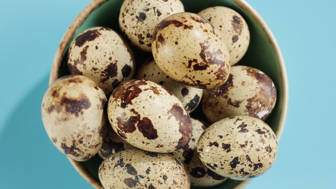 Quail eggs isolated on blue background top view. Healthy eating, dieting.