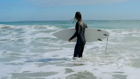 Hombre-Caminando-Con-Tabla-De-Surf-En-El-Mar-4k