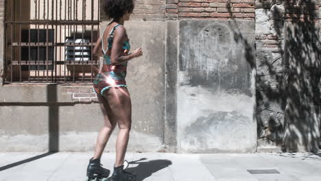 mujer de patinaje sobre ruedas baila y patina afuera en un entorno urbano