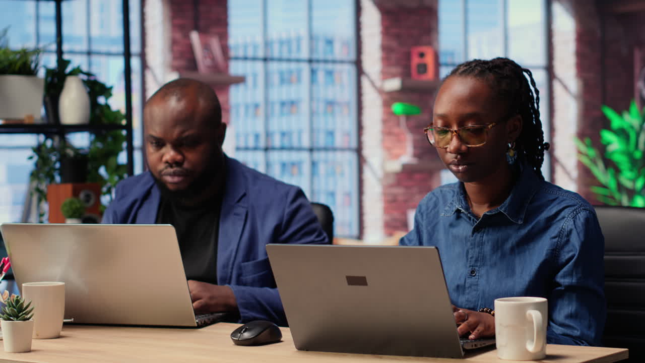 African american man and woman working remotely in their apartment