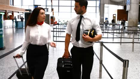 pilot and female flight attendant walking with luggage