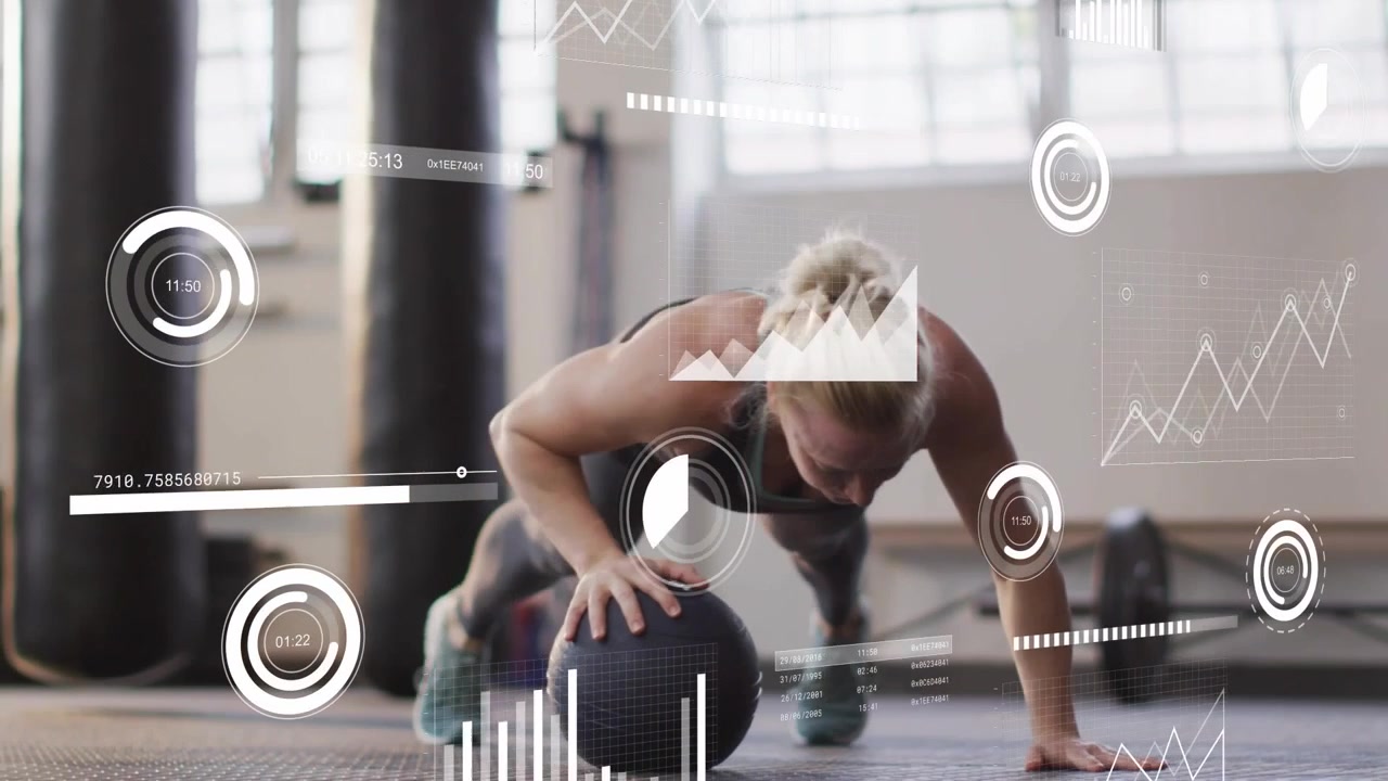 Vertical video: Doing athlete in leggings pushing on medicine ball in gym, timer tracking metrics