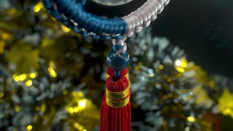 Dreamy-close-up-shot-of-a-Chinese-ancient-traditional-lucky-coin,-Asian-New-Year-decoration,-golden-shiny-blur-background,-square-hole-red-strings,-culture-holyday-symbol,-smooth-tilt-up-4K-video