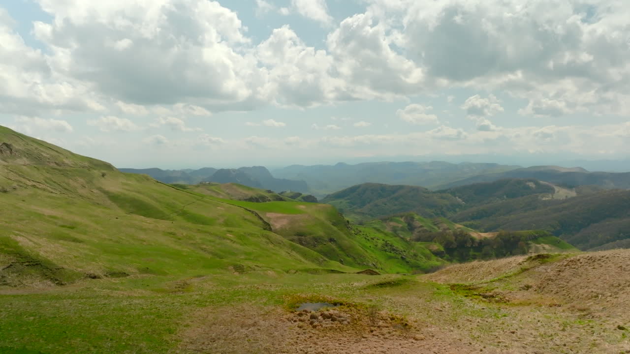 울창한 초록 잔디이 있는 산악 풍경