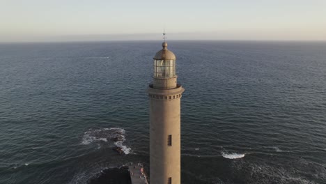 Stimmungsvoller-Abendleuchtturm-Bei-Sonnenuntergang-Mit-Meer-Und-Strand-Im-Hintergrund