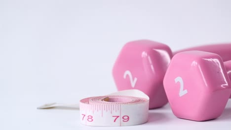 pink dumbbells and measuring tape