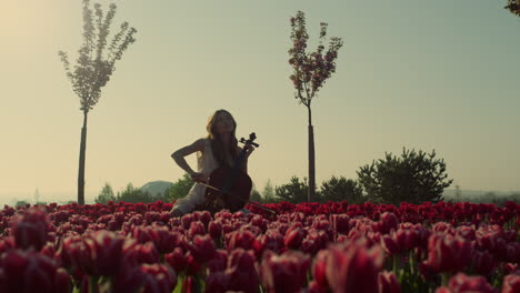 Chica-Desconocida-Tocando-El-Violonchelo-En-Un-Increíble-Campo-De-Tulipanes-En-Flor.-Jardín-Floreciente