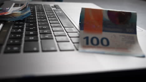 100 buck bank notes on a laptop, made from an online business generating cash