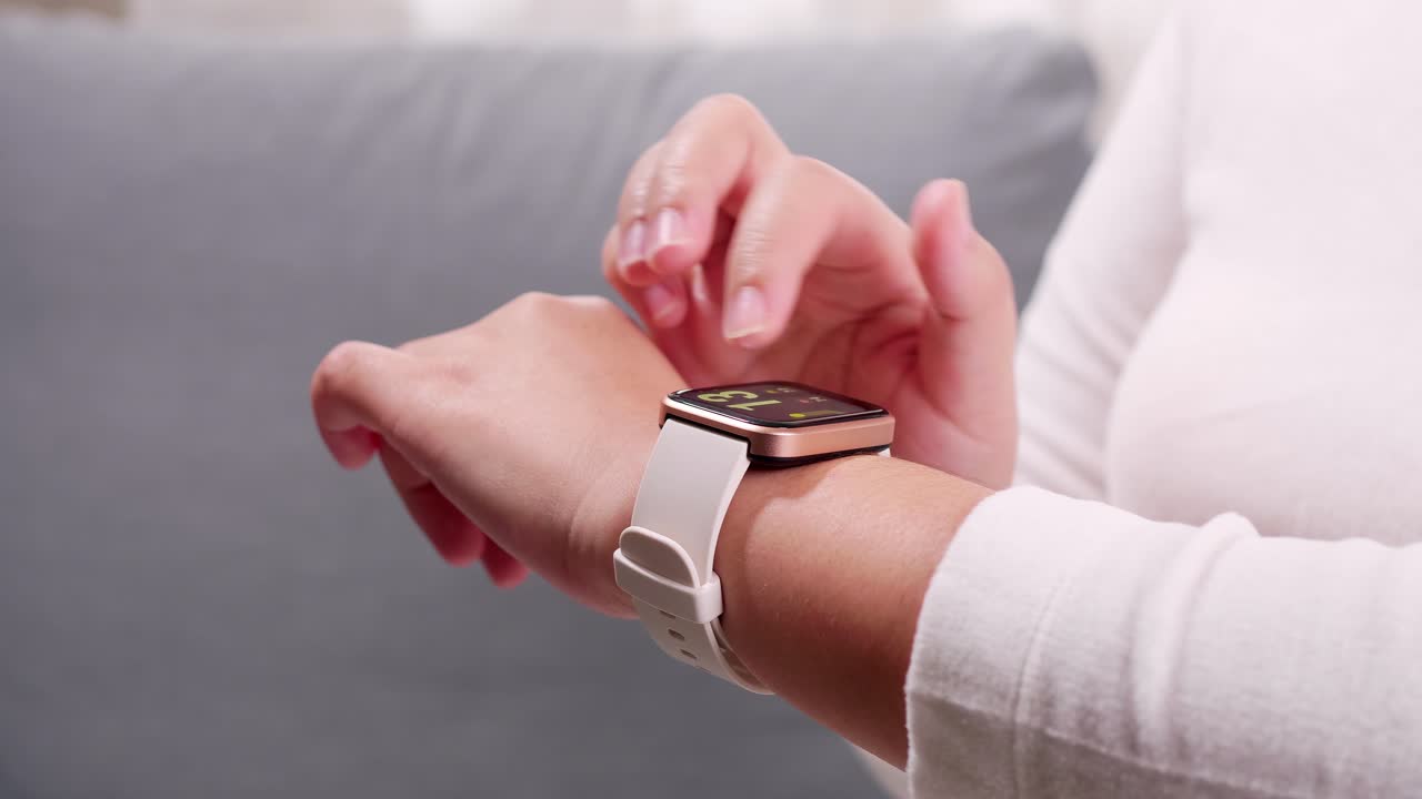 Close up shot of a woman hand who touch and scrolling on a smartwatch in order to quickly check application connect