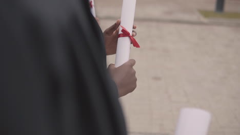 diploma in the hands of a black female graduate