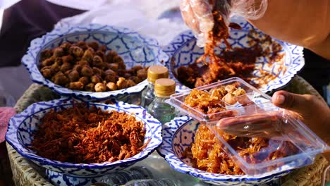 vendor packs shredded pork into a container