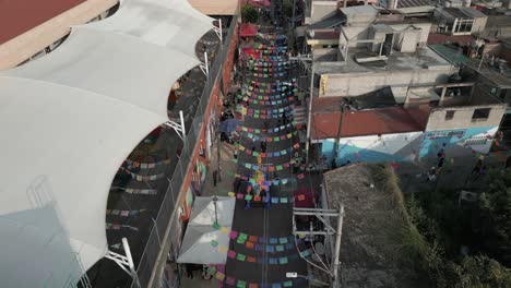 Flyover-colorful-banners-on-narrow-Mixquic-street-on-Day-of-the-Dead