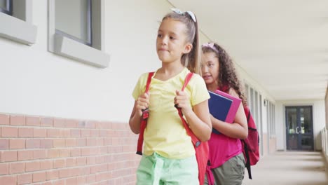 Video-of-happy-diverse-girls-walking-at-school-corridor