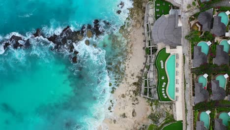 beautiful infinity pool overlooking turquoise tropical waves crashing