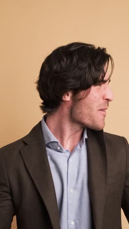successful businessman clenching fists in brown studio