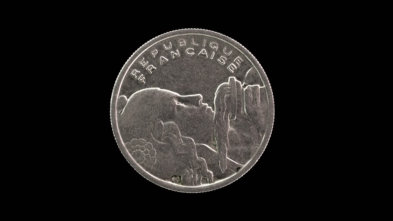 France 1955 100 francs coin obverse with the bust of Liberty holding a torch rotating on black background