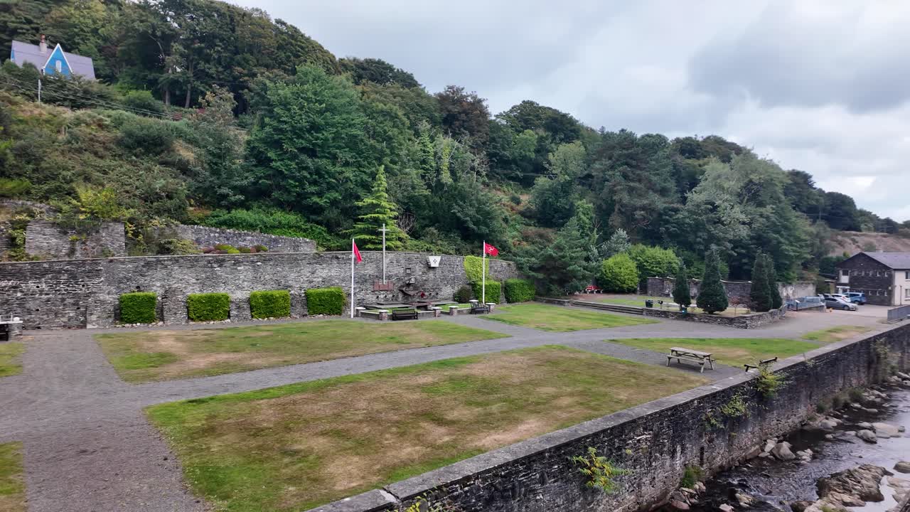 Laxey Glen Gardens park showcasing stone walls, paths, and benches with a lush hillside background