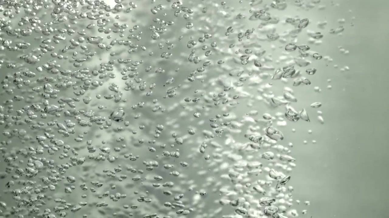 Primo piano di molte bolle d'aria che salgono in acqua limpida