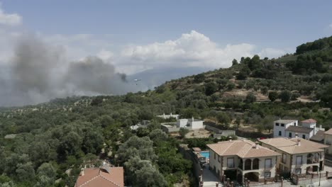 Helicopter-fighting-forest-fire-in-Spanish-village,-no-people