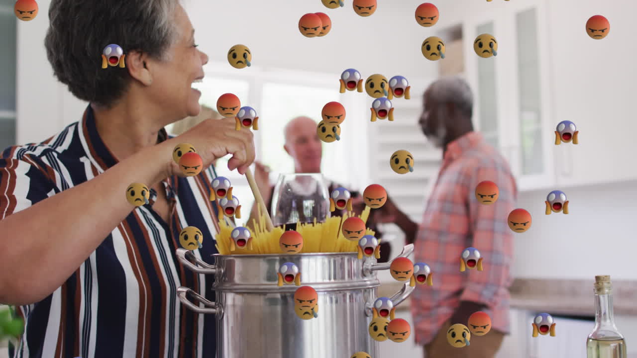 Multiple face emojis floating against african american senior woman cooking spaghettis at home