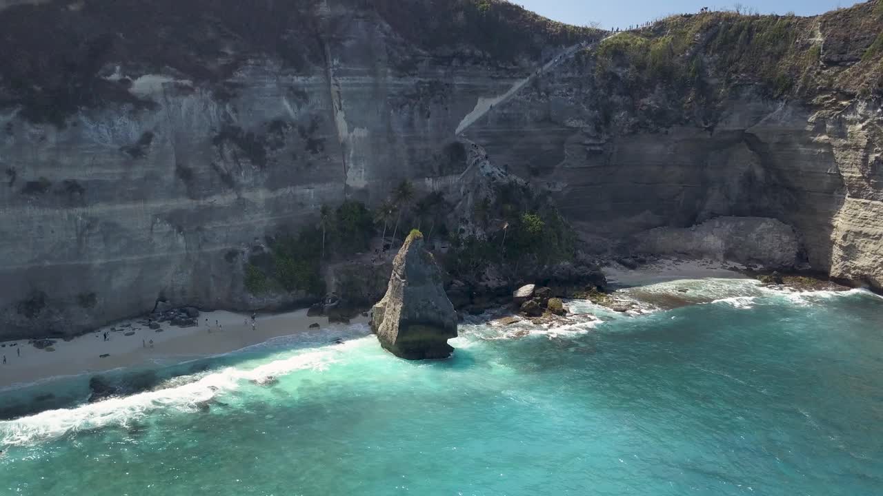 vista aérea del agua azul cristalina de la playa de diamantes en nusa penida, indonesia, con un gran acantilado prominente en primer plano